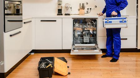 Open dishwasher with technician tool case in a modern kitchen