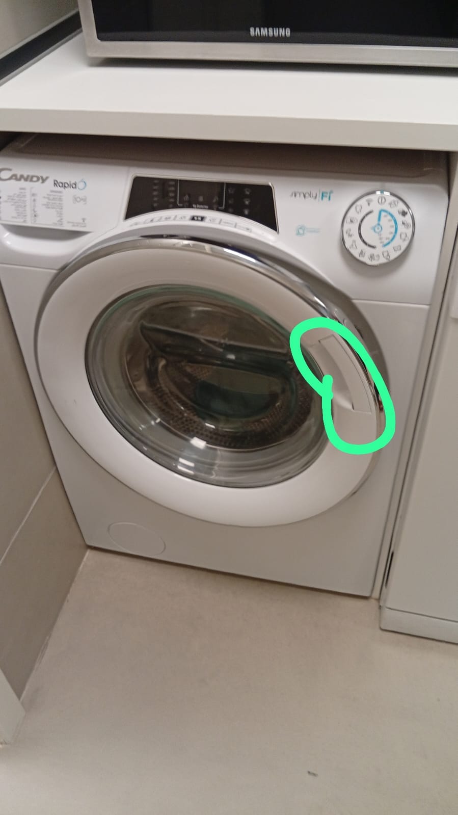Front-load washing machine with the door latch area marked as the reported fault
