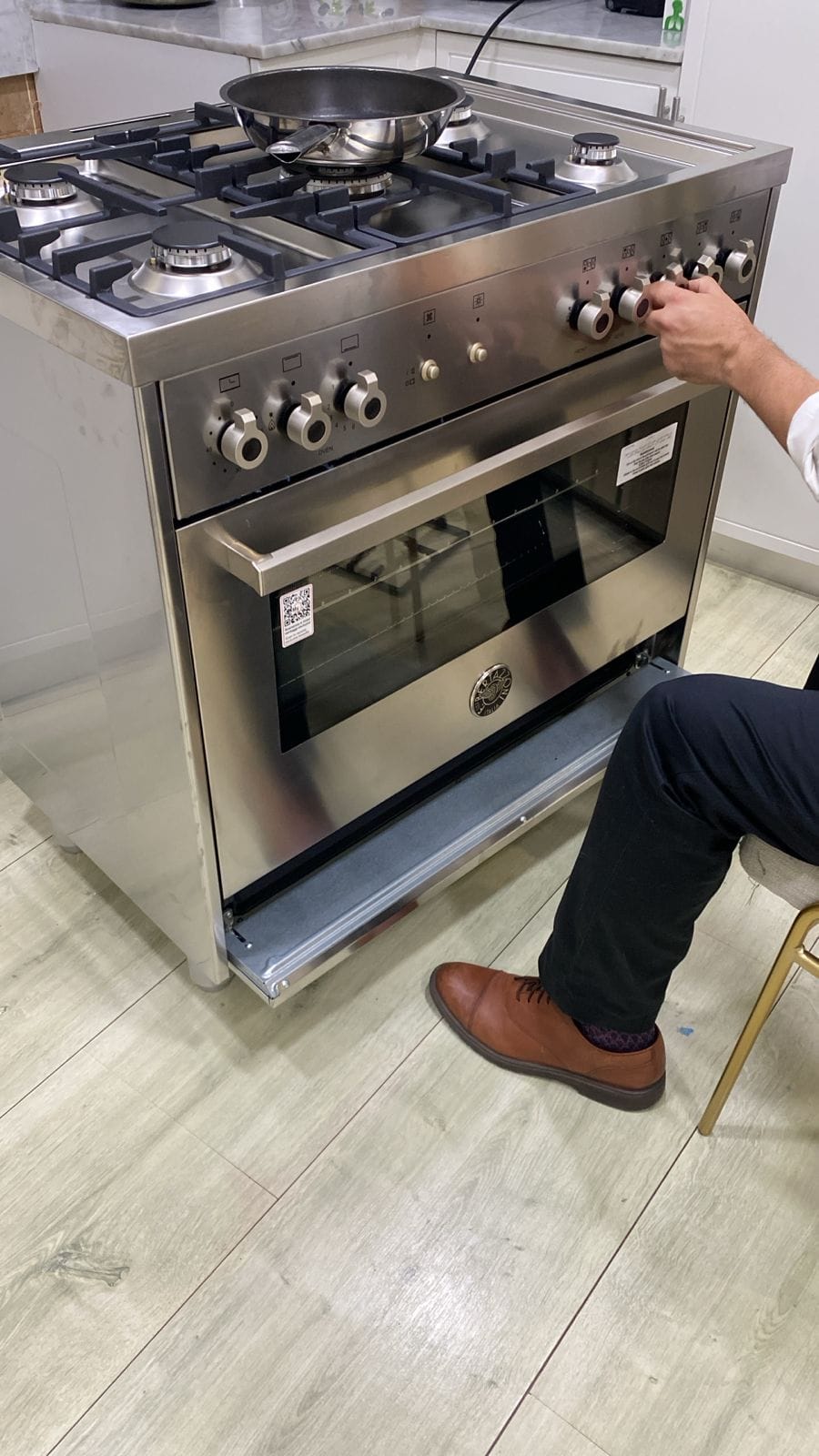 Range controls being checked with the oven door open during commissioning, UAE
