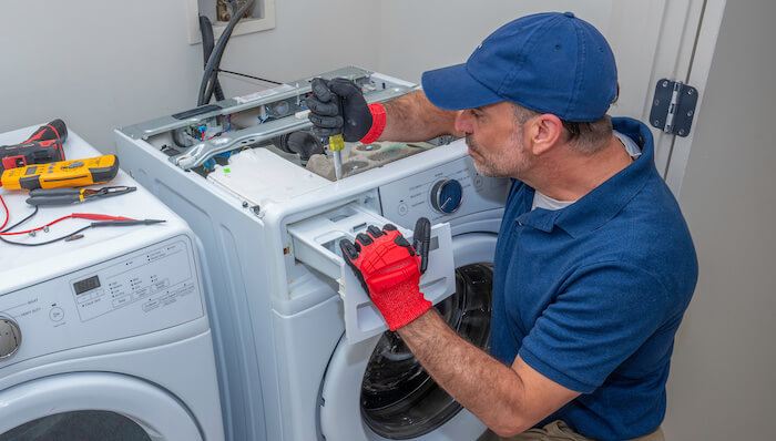 Technician repairing the control panel of a front-load washing machine